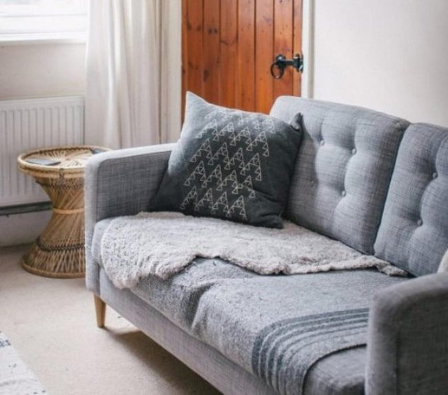 Gray Couch With Wicker Accents