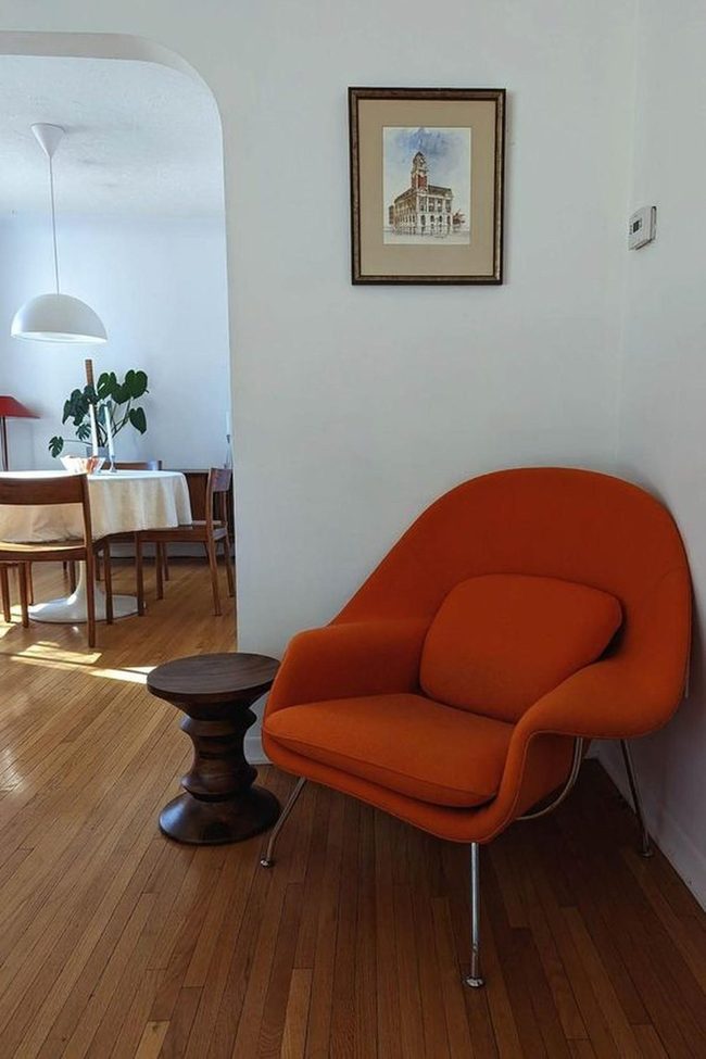 Orange Chair Anchors Warm Wood Space