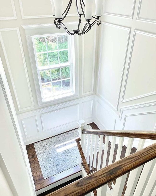 Black Chandelier Above Warm Wood Stairs
