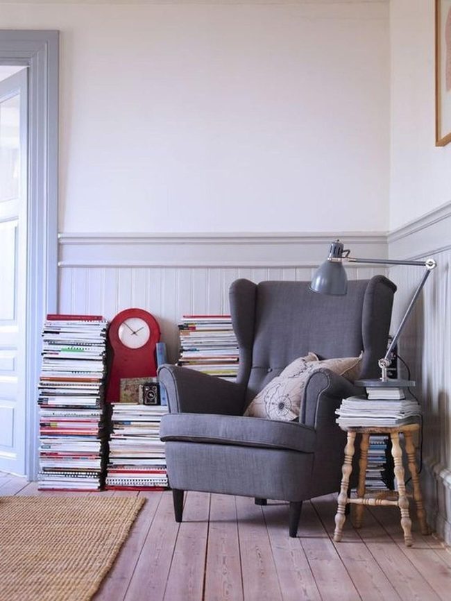 Gray Armchair Reading Corner With Stacked Magazines