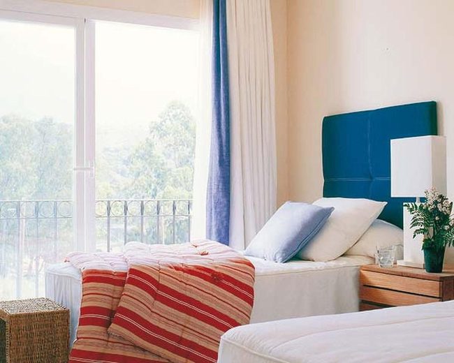 Deep Blue Headboard Meets Sunlit Bedroom