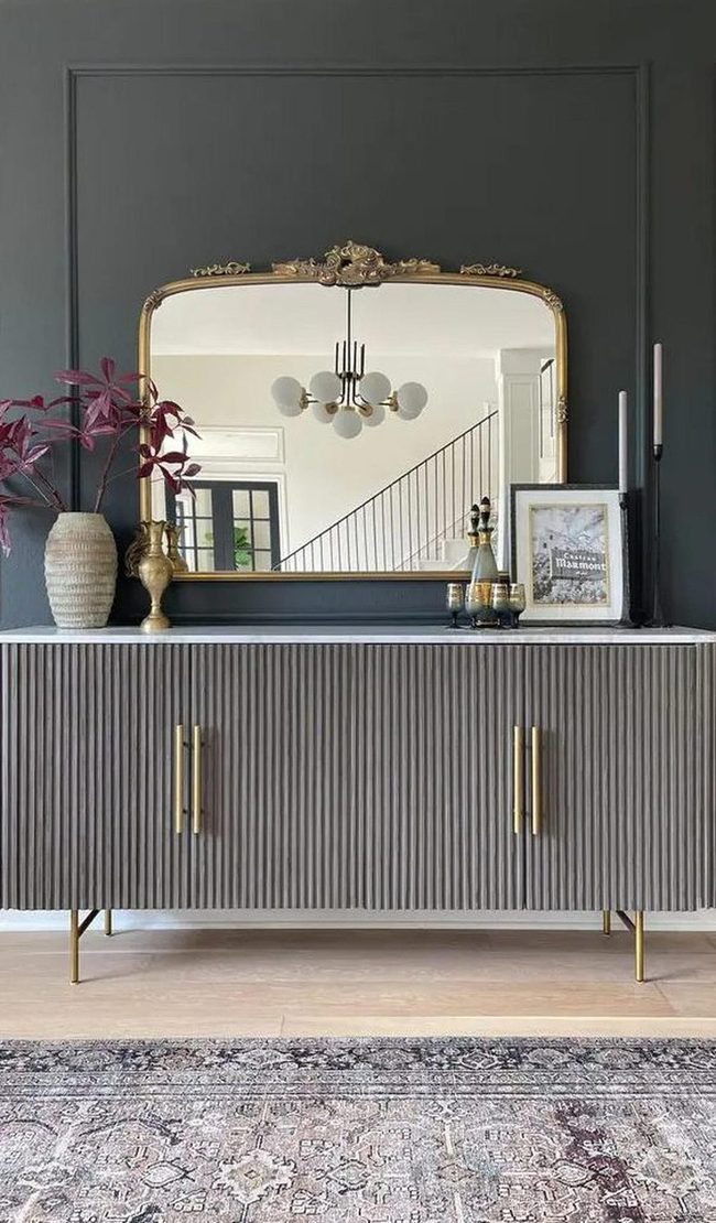 Gold Mirror Reflects Chandelier Light