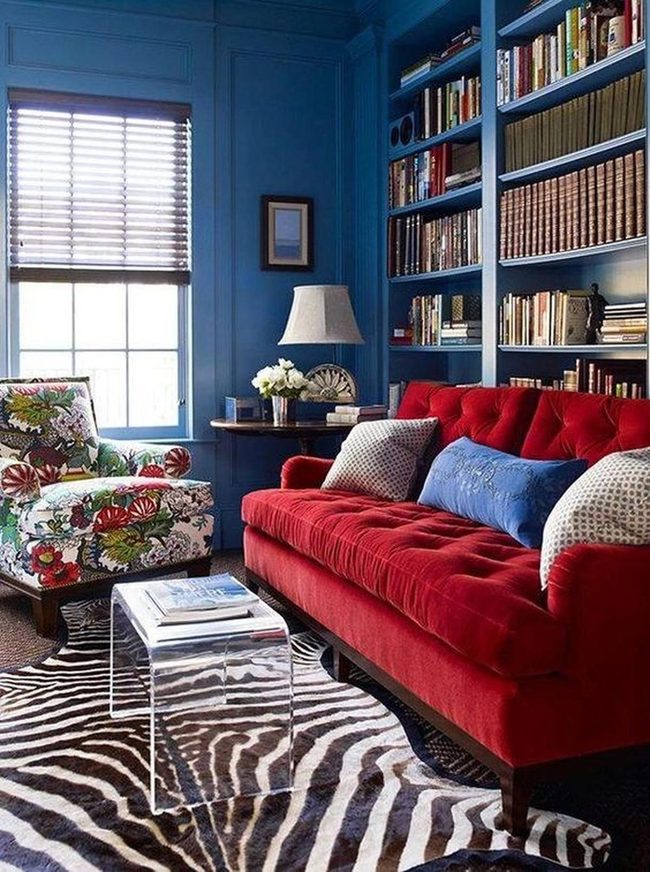 Deep Blue Walls With Colorful Books And Red Statement Sofa