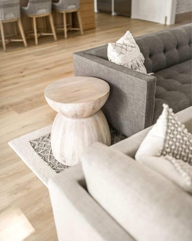 Gray Tufted Couch With Warm Wood Accents